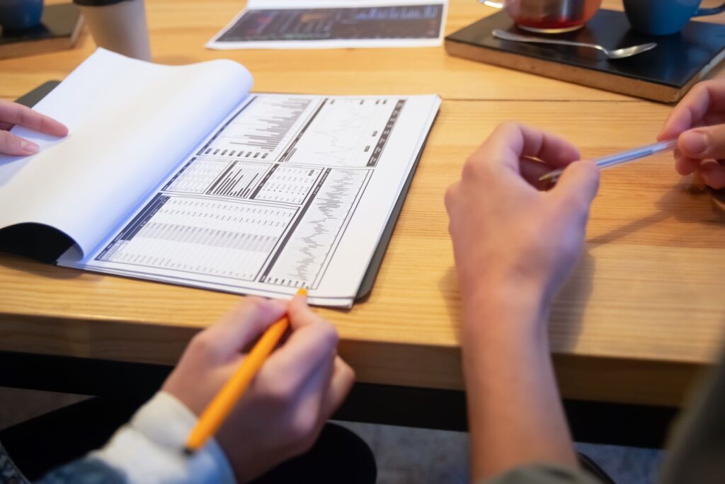 Close-up of colleagues reviewing analytics at a wooden table in a casual setting.
